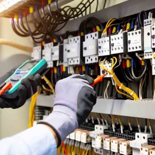 An electrician working on a complex electrical panel